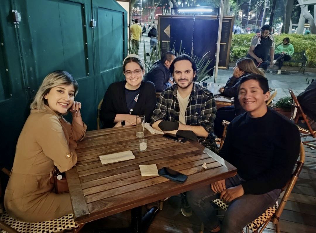 4 people around a table: a woman with blonde highlights and a brown dress, me with a white head covering and black shawl, a man with chin-length hair and a plaid shirt, and a short-haired man in a black shirt /images/2023/lorena_maco_raul_carlo.jpg